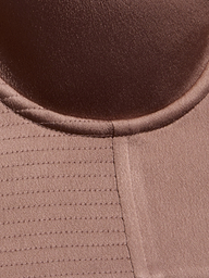 Close-up of a brown fabric with a circular seam at the top and parallel stitched lines on the left, showing texture and stitching details from the Nysa Bustier Top.