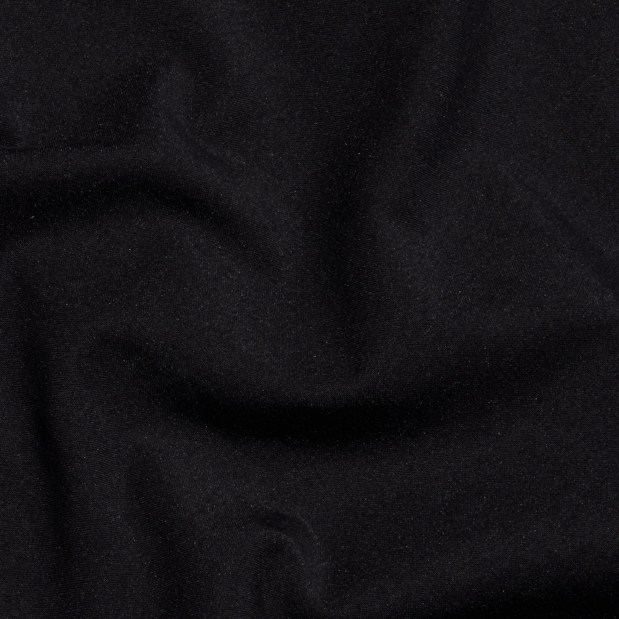 A close-up of the Sarai Off-The-Shoulder Top in black organic cotton-blend fabric, featuring subtle folds and wrinkles that highlight its smooth texture and soft sheen.