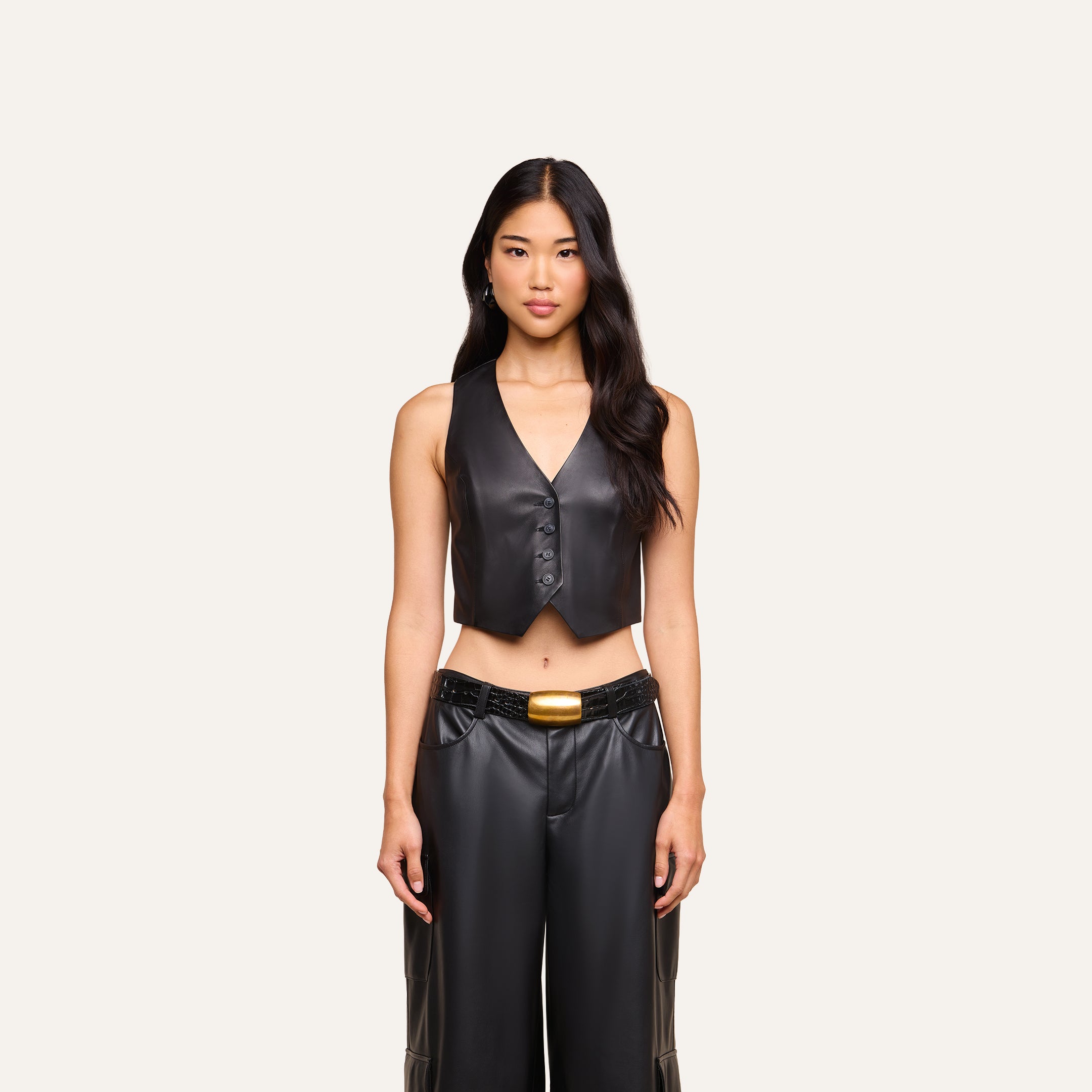 A woman stands facing forward, showcasing the Jianna Leather Vest paired with matching black leather pants and a belt against a plain light background—a look inspired by Fall 2026 fashion.