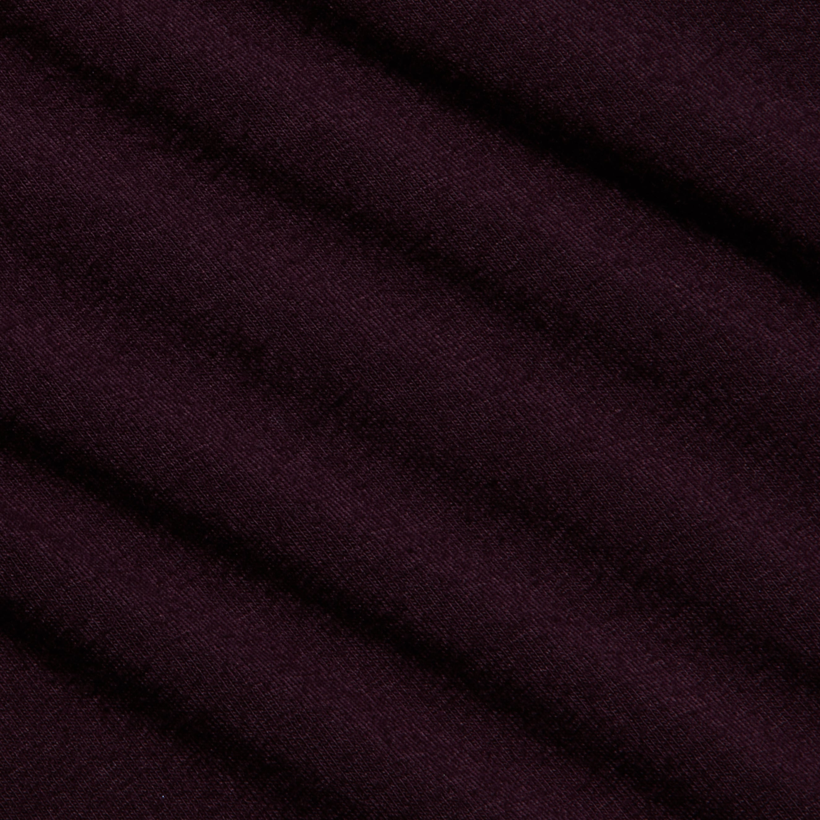 Close-up of the Lani Turtleneck’s deep purple fabric with a diagonal ribbed texture and soft, matte finish—ideal for Fall 2026. The material appears smooth, with gentle shadows accentuating the folds.