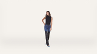 Woman standing against a plain white background, wearing a sleeveless black top, blue jeans, and black over-the-knee boots with blue pointed toes. She has straight brown hair and her left hand is on her hip.