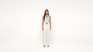 A woman stands facing forward against a plain white background, wearing a light blue tank top, white high-waisted pants, and open-toe heels. Her arms are relaxed by her sides.
