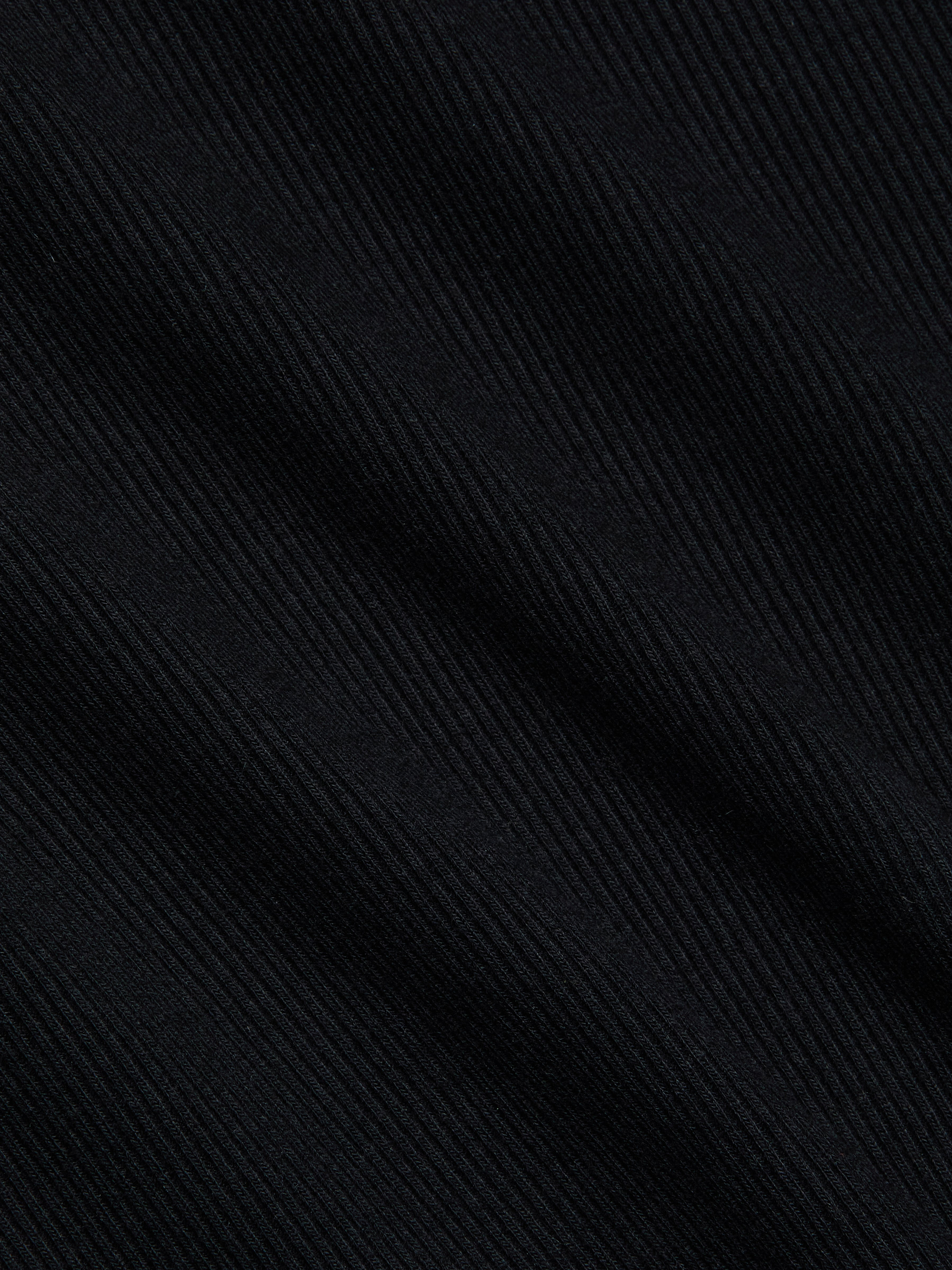 Close-up of the Brynlee Scoopneck Tee in black, crafted from stretch cotton ribbed fabric with diagonal textured lines that form a subtle striped pattern and offer a soft, slightly glossy finish.