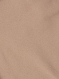 A close-up of the Mietta Knit Bandeau Top’s light brown fabric showcases subtle diagonal weave patterns and gentle creases, highlighting the stretch nylon material often used in supportive bandeau styles.