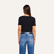 A person with straight brown hair is seen from behind against a plain white background, wearing blue jeans, a shiny black belt, and the Brianna Cotton V-Neck Tee in black, made from Supima cotton.
