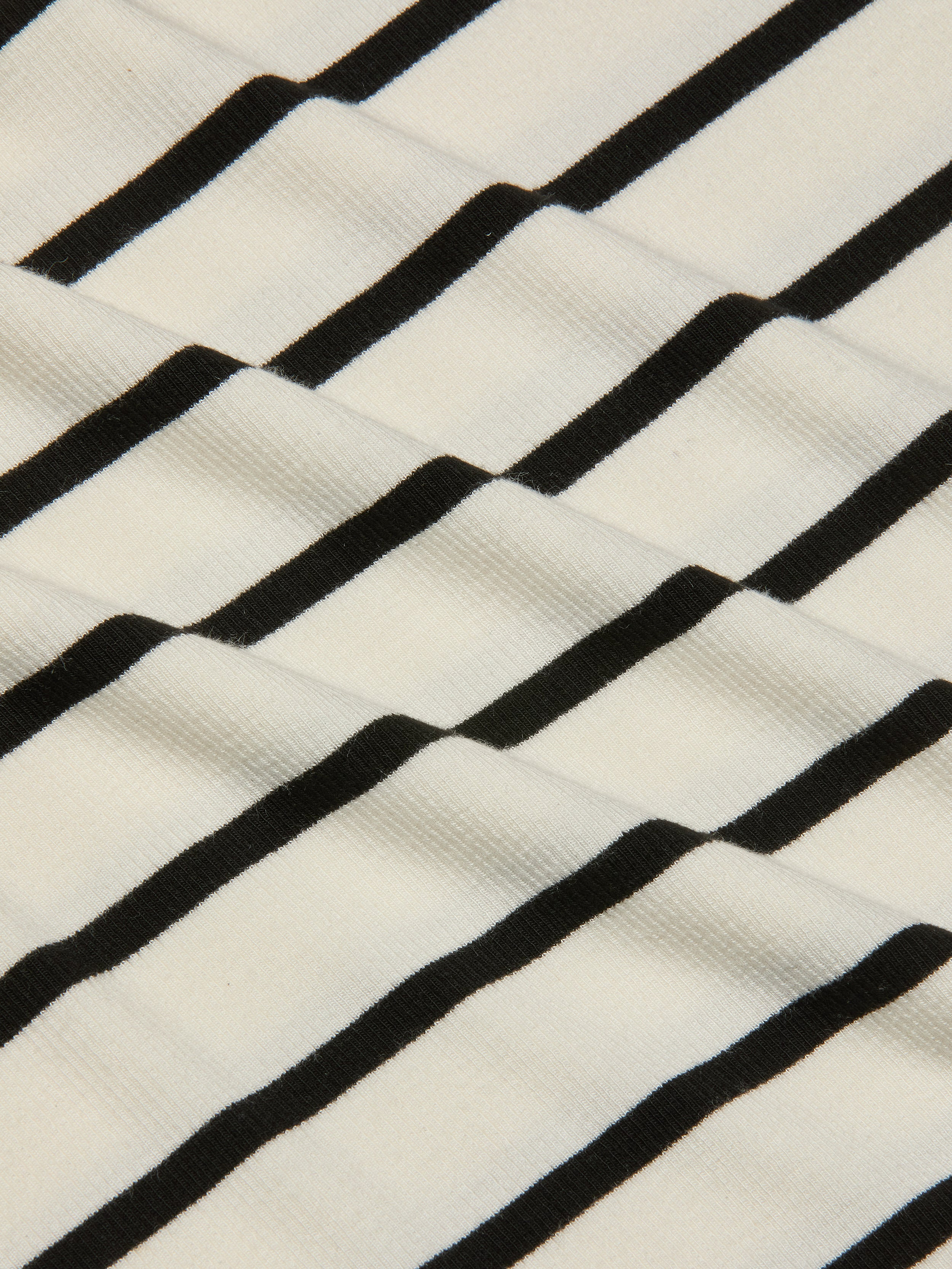 Close-up of the Nura Racerback Midi Dress fabric, featuring black horizontal stripes on a white background that create a wavy, textured pattern.