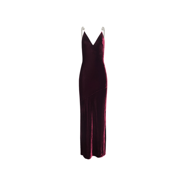 The Saint Velvet Gown is a sleeveless dress in deep burgundy velvet, featuring a V-neckline and sparkling rhinestone straps, showcased against a plain white background.