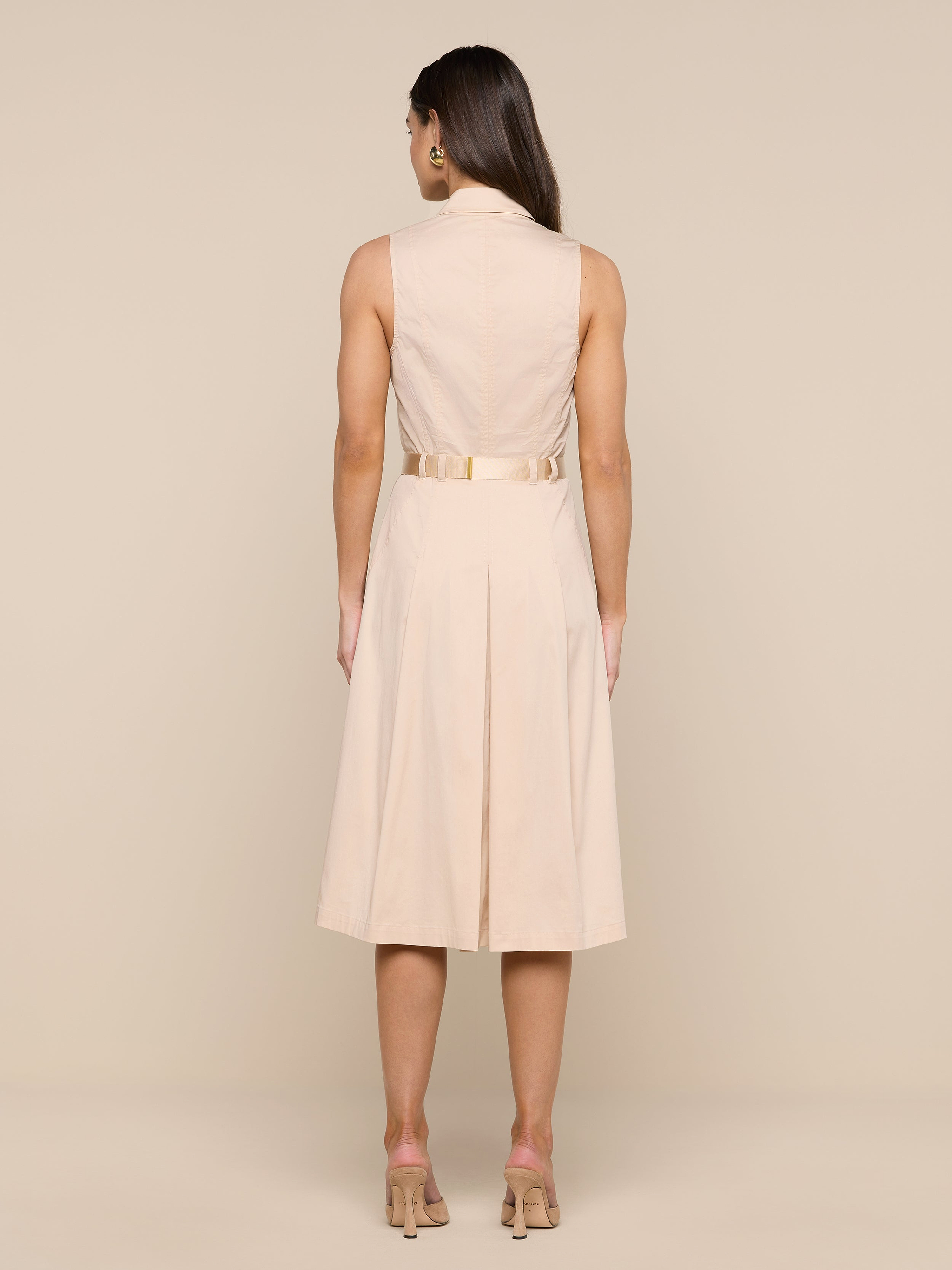 A woman stands facing away, wearing the Kylo Poplin Shirt Dress with nude heels, against a plain white background.