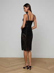 A woman in the Jennifer Lace Midi Dress, featuring sheer floral lace, and heels stands against a plain white background, facing away but looking over her shoulder.