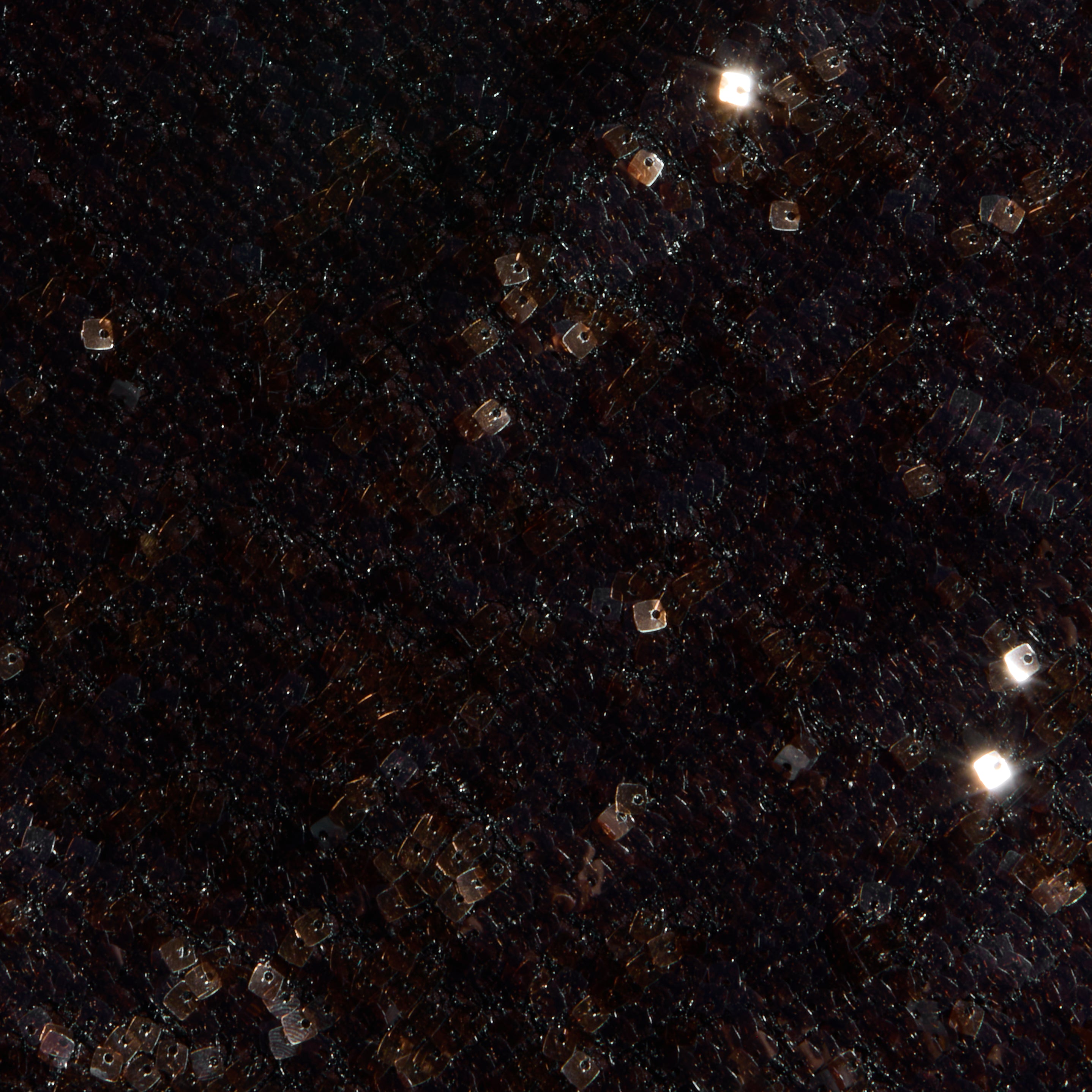 A dark, grid-patterned surface studded with glowing square white and orange lights, scattered like stars or pixels, conjures the dazzling effect of the Sayla Sequin Gown—an event-ready dress designed to shine at any occasion.