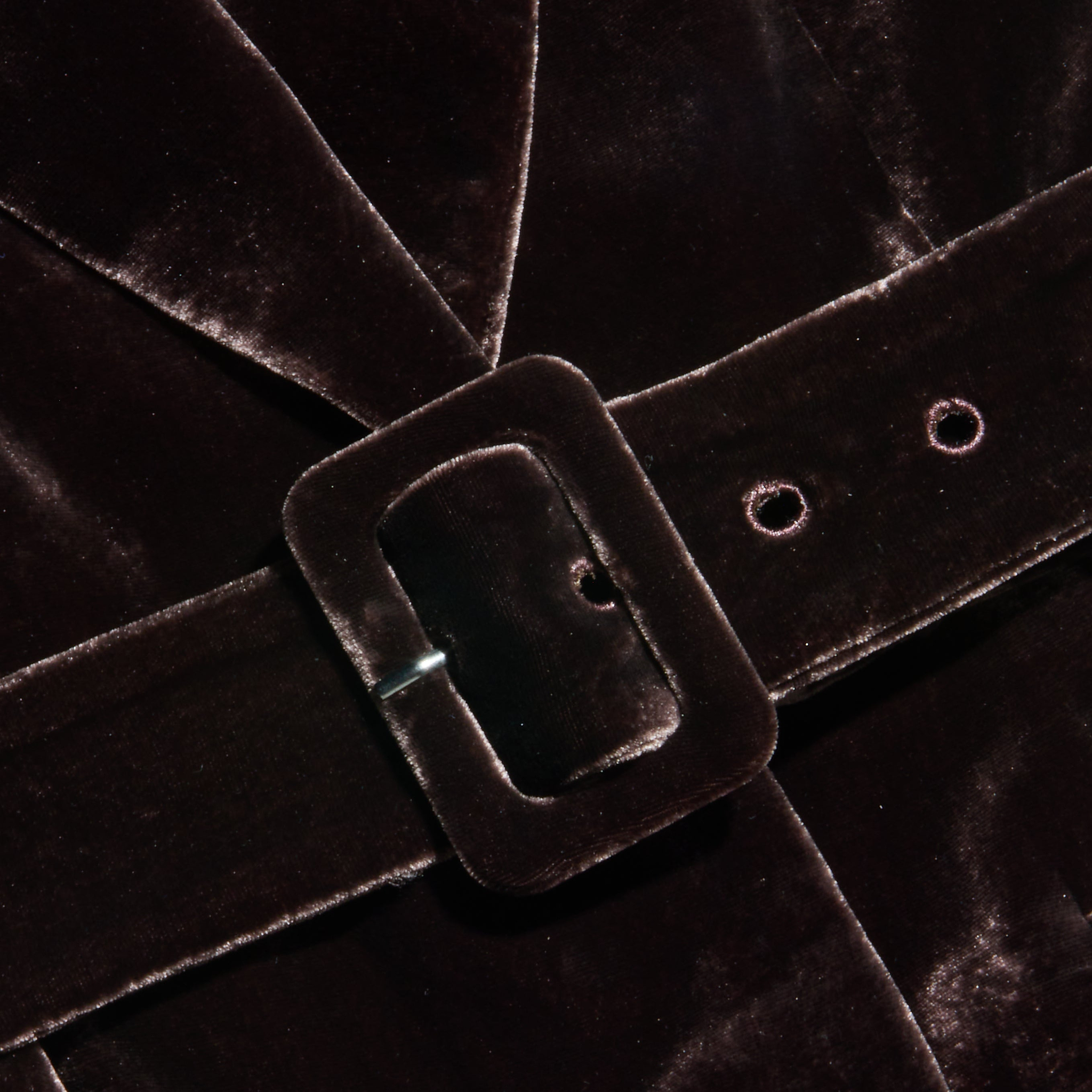Close-up of the Raini Velvet Maxi Dress in dark brown, featuring a matching velvet belt with a rectangular buckle fastened around the waist. The soft, slightly reflective texture of the luxurious velvet fabric highlights elegant details, making this dress perfect for Fall 2026 fashion.