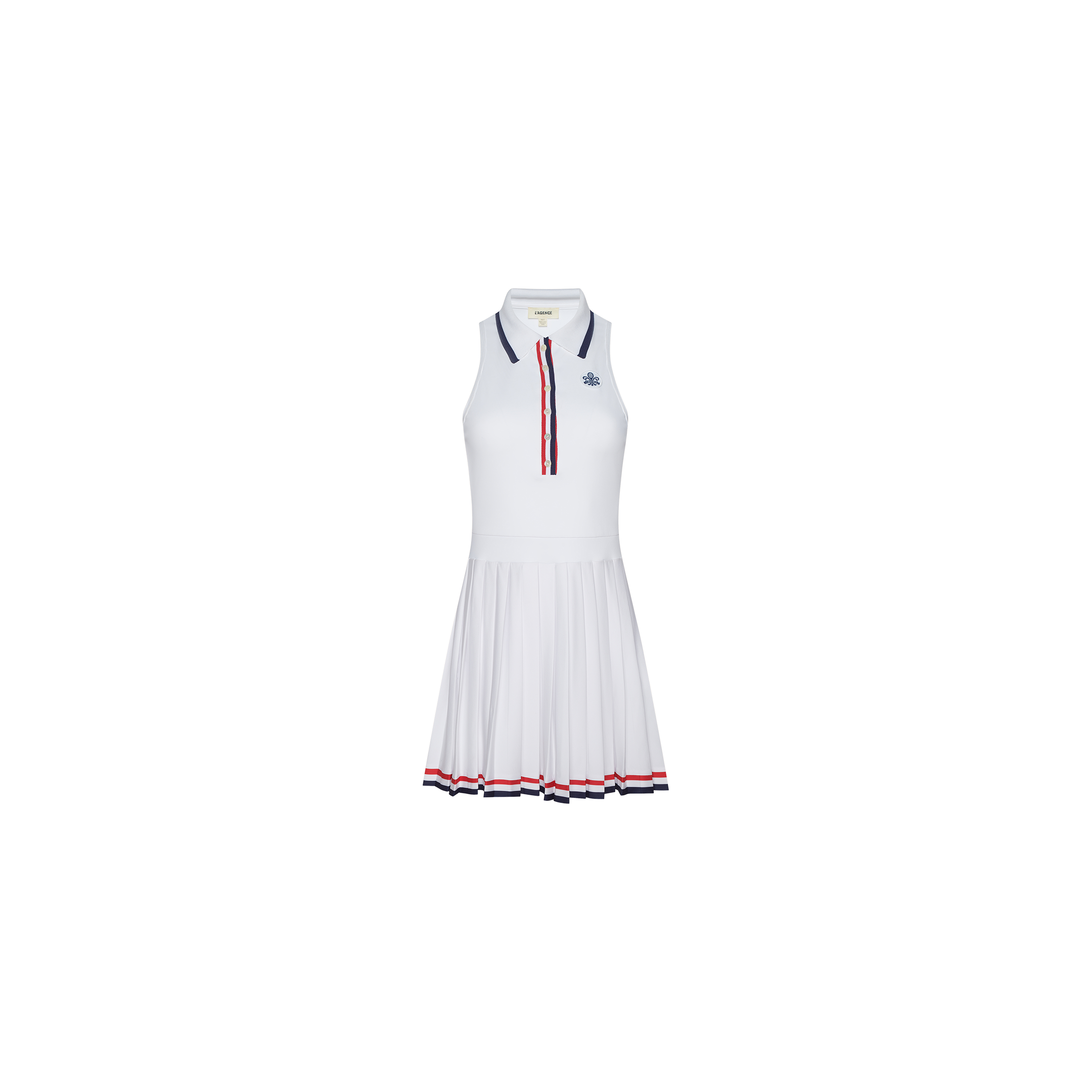 The Winny Polo Tennis Dress is a sleeveless white tennis dress featuring a pleated skirt, navy and red accents on the collar and placket, and matching trim at the hem. It includes a small logo on the chest and built-in shorts for added comfort and coverage.