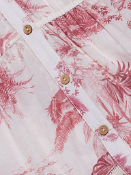 Close-up of the Serafine Midi Dress, crafted from a lightweight voile fabric in light pink with a red botanical print. The image highlights four brown buttons on the sewn placket, with visible stitching and pleats above the top button.