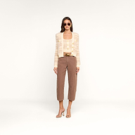 A woman wearing sunglasses, a beige striped cardigan with decorative buttons over the Galene Tank, brown cropped pants, and beige high-heeled sandals stands against a plain white background.