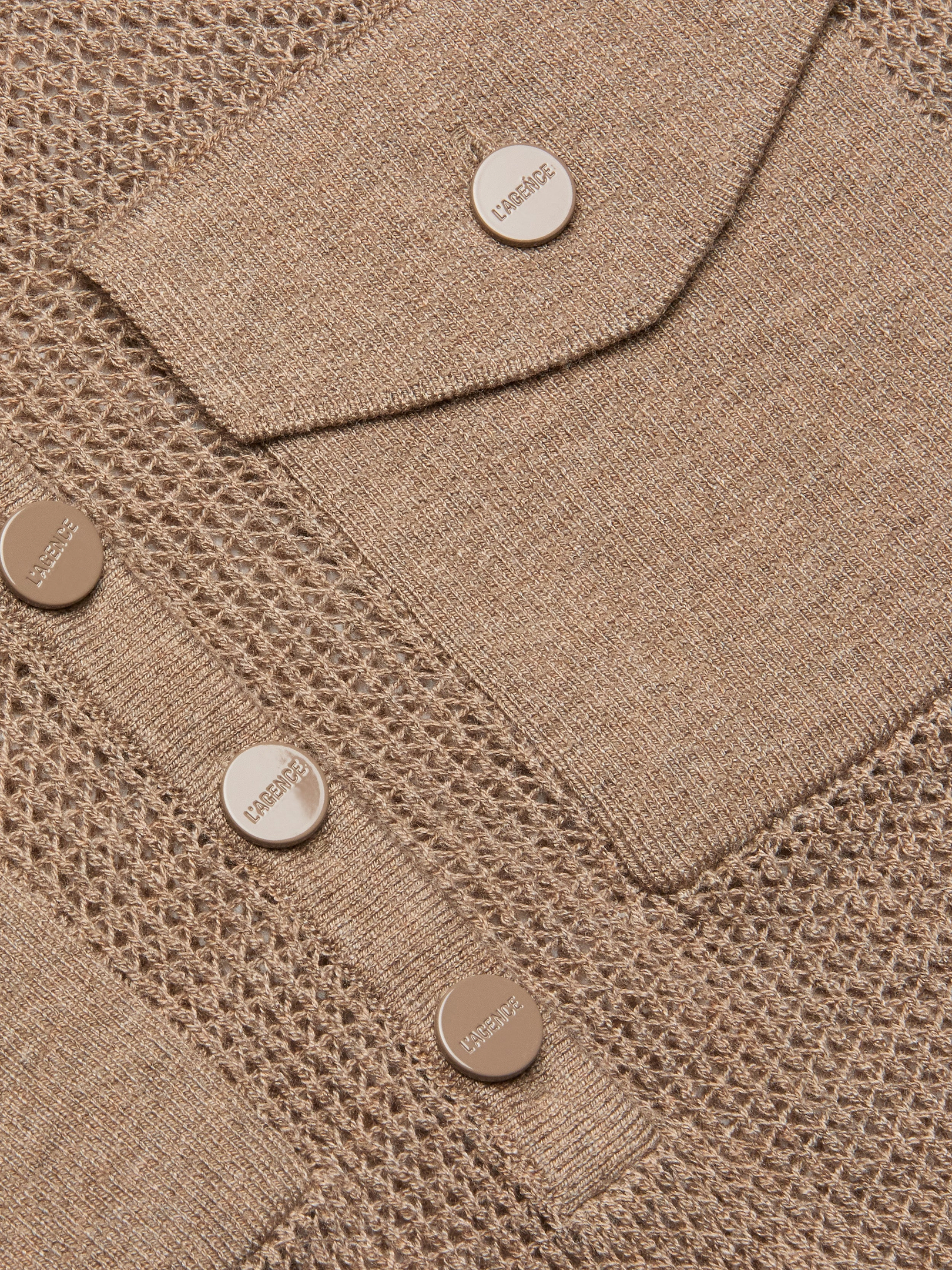 Close-up of the Carine Top in beige lightweight knit fabric with mesh and solid patterns, featuring metallic buttons embossed with LABISSE and a utility pocket flap.