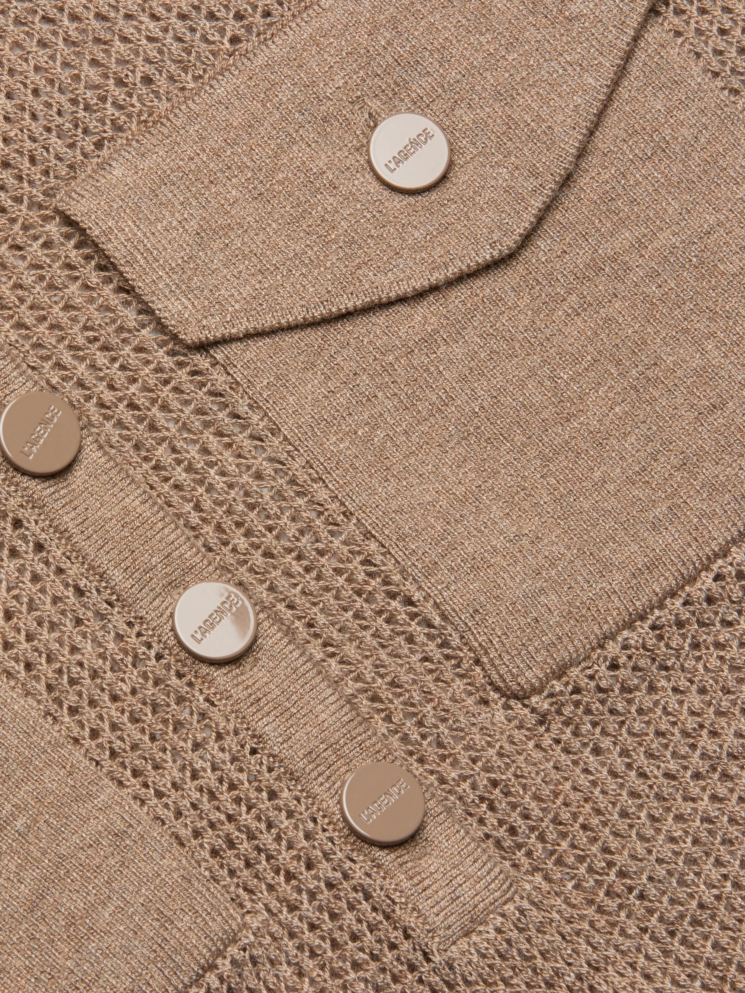Close-up of the Carine Top in beige lightweight knit fabric with mesh and solid patterns, featuring metallic buttons embossed with LABISSE and a utility pocket flap.