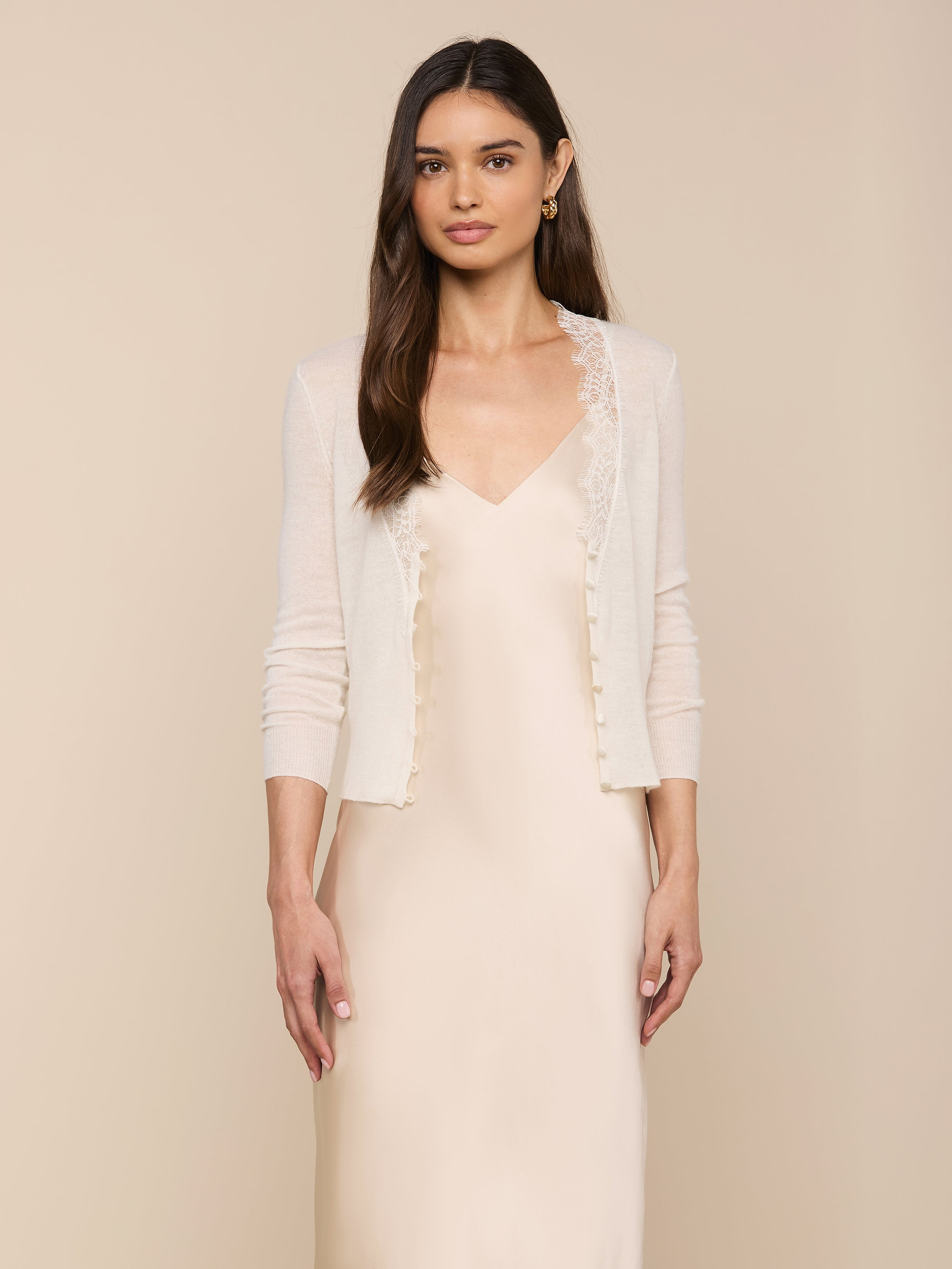Wearing the Eluna Cardigan Top over a matching satin slip dress, a woman with long brown hair stands against a plain light background.