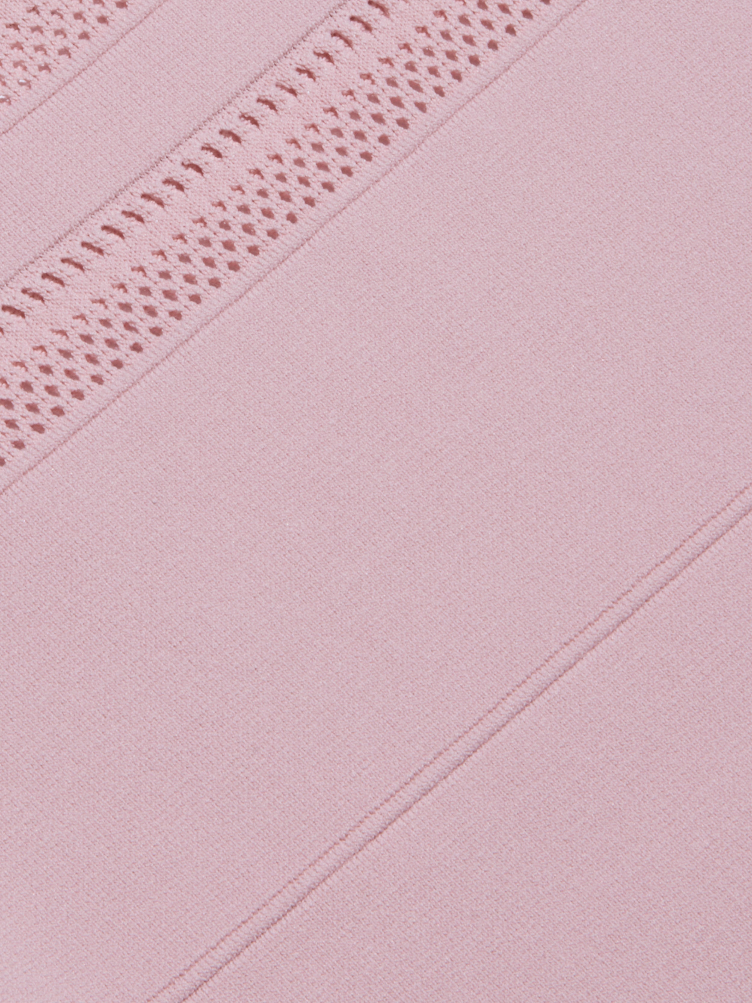 Close-up of the Taren Knit Dress in pink, featuring power knit fabric with diagonal lines and a section of intricate crochet or lace detailing, creating a textured and patterned appearance.