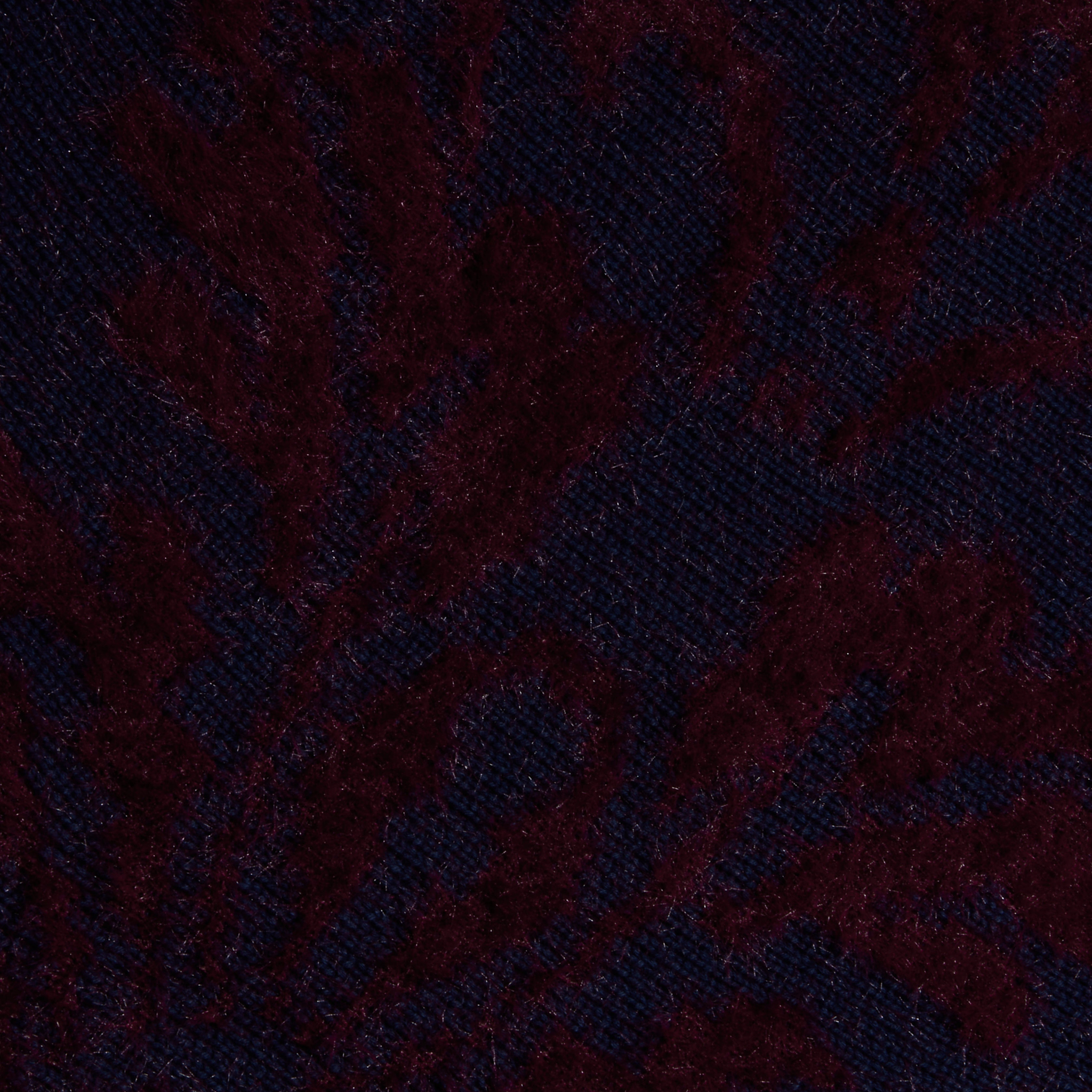 Close-up of the Naiad Jacquard Fringe Cardigan, featuring dark purple and black jacquard knit fabric with a subtle leafy or floral pattern, for a rich and soft look.