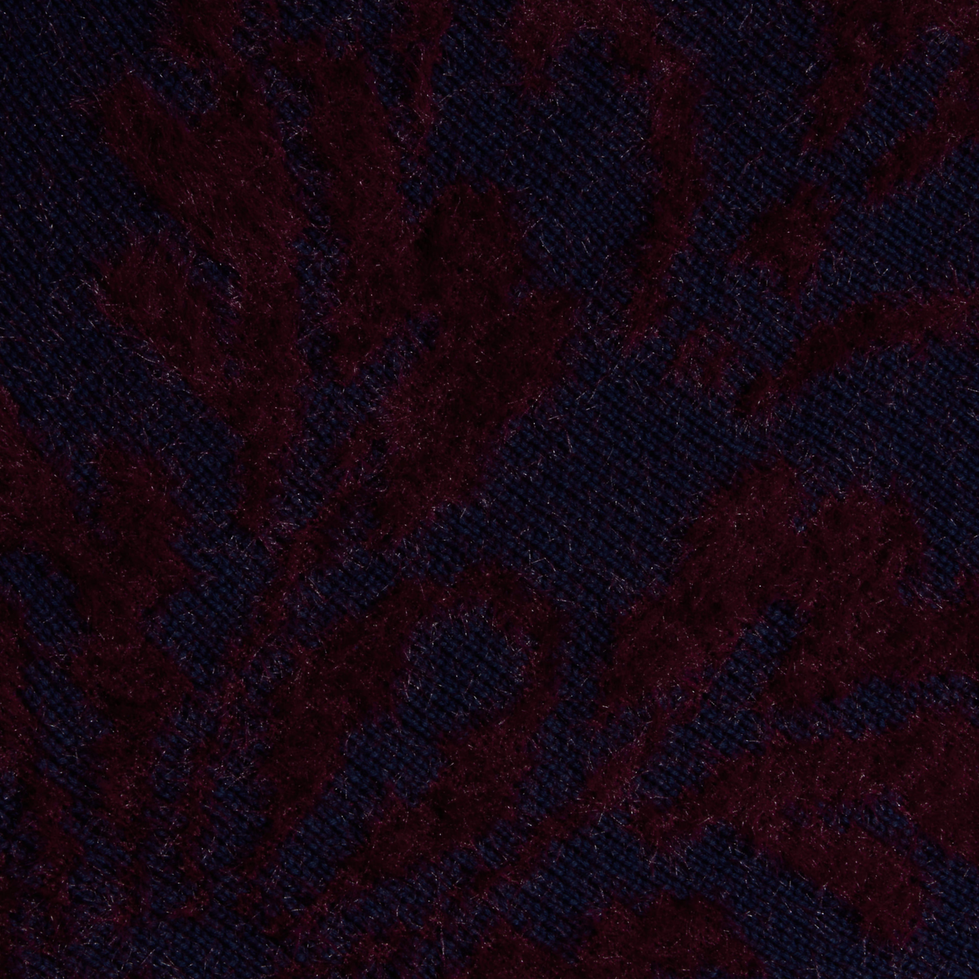 Close-up of the Naiad Jacquard Fringe Cardigan, featuring dark purple and black jacquard knit fabric with a subtle leafy or floral pattern, for a rich and soft look.