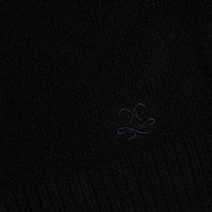 A close-up of the Filou Cashmere Tank in black, showcasing its textured fabric and a subtle embroidered design with flowing, intersecting lines near the center—an ideal detail for luxury layering or building your sweater capsule.