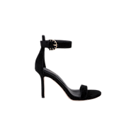 The Gisele Suede Sandal is a black ankle-strap sandal crafted from suede, showcasing a gold buckle, an open toe, and a fashionable stiletto heel, presented against a plain white background.
