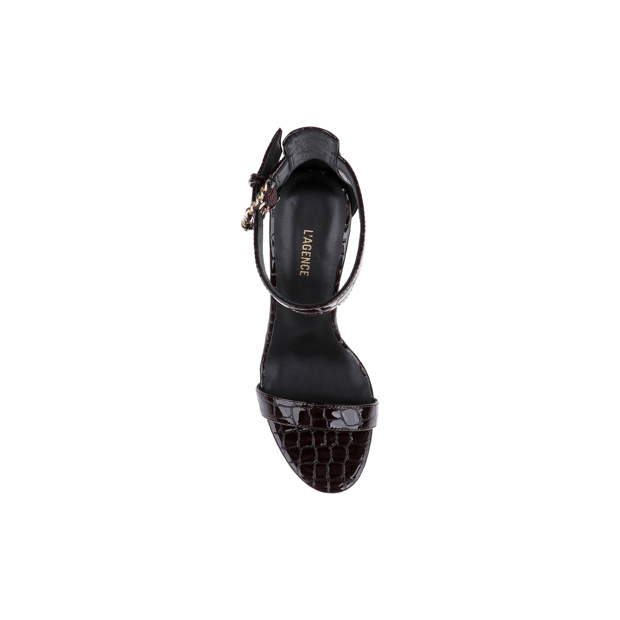 A black Gisele Leather Sandal, crafted with crocodile-embossed leather and an ankle strap adorned with a gold buckle, is displayed from above against a white background. The insole features the LARGRICE logo in gold lettering.