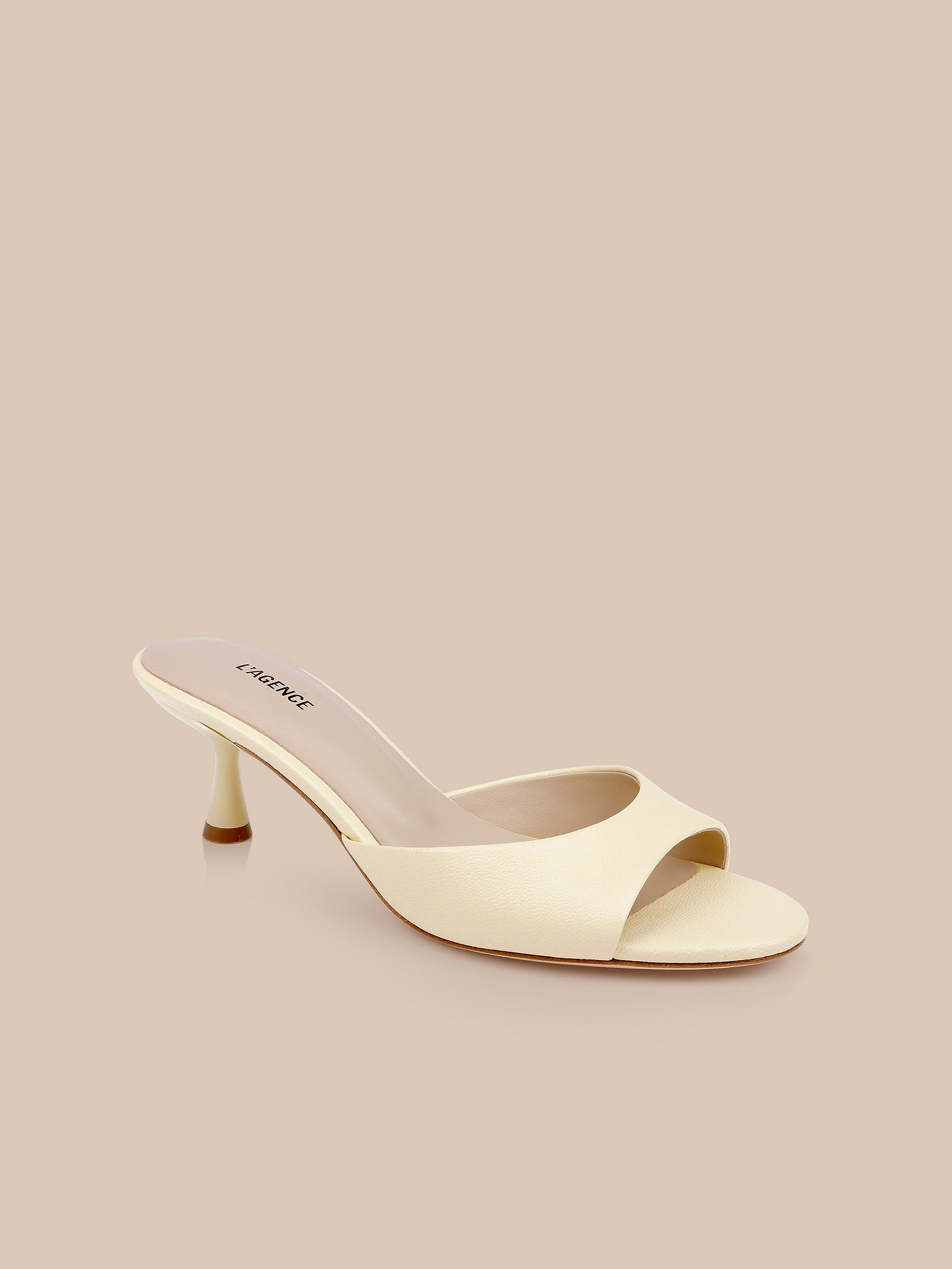 Arleen Kitten-Heel Mule: a cream-colored leather mule featuring a low kitten heel and minimalist open-toe design, set against a solid beige background.