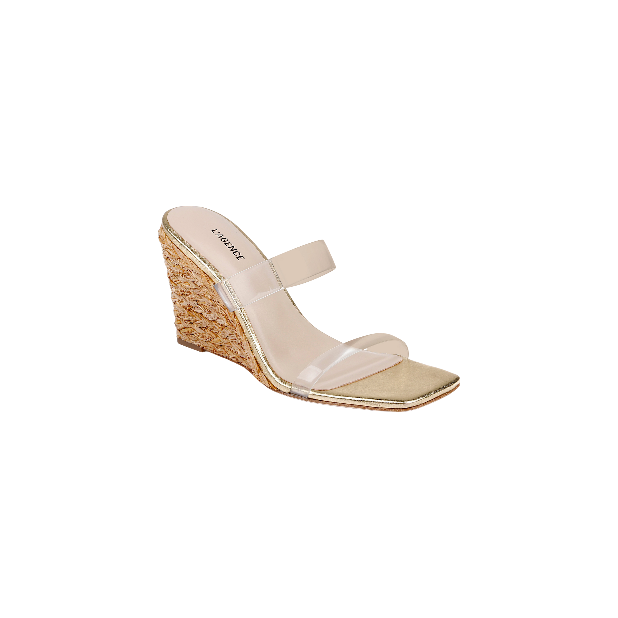 The Farrell Wedge Espadrille features a gold finish with a woven raffia wedge heel, square toe, and two clear straps across the top, displayed on a white background.