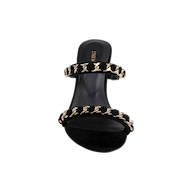 The Sarika Chain Sandal, crafted in black suede, features two straps embellished with bold gold chain hardware and is displayed from a top-down perspective against a plain white background.