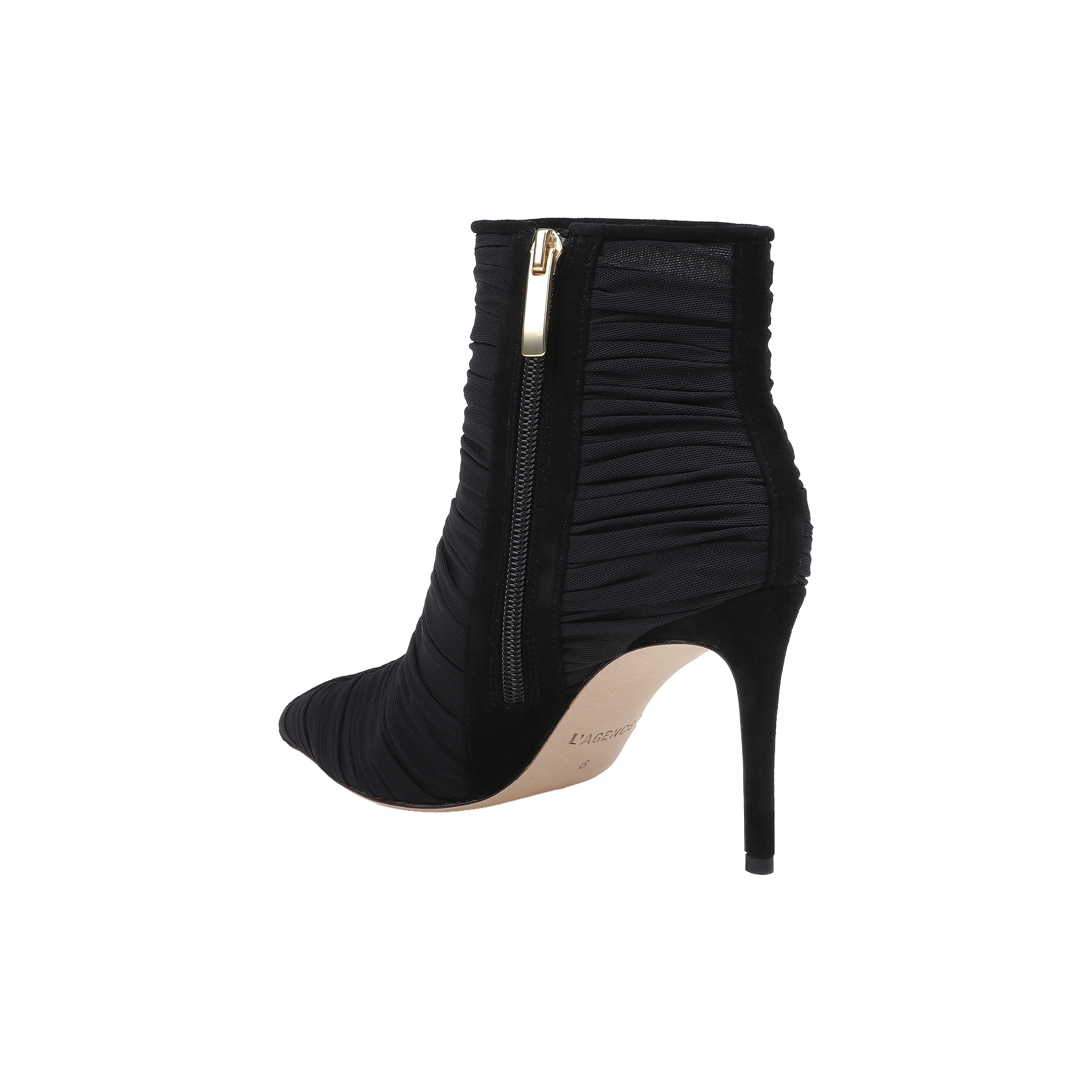 The Fulton Mesh Bootie is a black stiletto bootie featuring ruched mesh fabric, a pointed toe, and a gold side zipper. This heeled bootie showcases a slim stiletto heel and a light-colored sole.