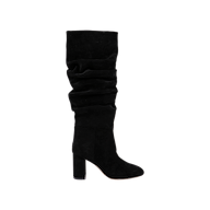 The Fletcher Boot—a black slouchy suede boot with a tall block heel and a ruched shaft— is displayed on a plain white background, offering a touch of bohemian chic style.