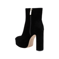 The Soho Bootie is a black suede ankle boot featuring a thick platform block heel, side zipper, and beige sole, displayed against a plain white background.
