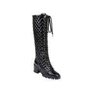 Tribeca Boot: A black knee-high lace-up combat boot featuring a chunky block heel and a textured geometric pattern on the shaft, crafted from glossy patent leather and displayed against a plain white background.