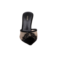 The Semois Mule is a single lace-capped mule with a pointed toe, showcasing a black lace upper, beige mesh sides, and a black insole embellished with the word MAGGIE in gold lettering. It is displayed against a plain white background.
