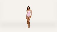 A woman stands facing forward, wearing a light pink one-piece swimsuit against a plain white background.