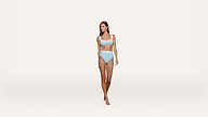 A woman stands against a plain white background, modeling a light blue, textured bikini with high-waisted bottoms and a matching top. She is barefoot and looking slightly to the side.