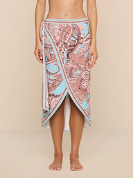 Barefoot against a plain white background, a person showcases the Marena Sarong in light blue and pink paisley print, embodying effortless beachside sophistication.