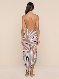 Eine Frau steht barfuß mit dem Gesicht zur Wand und trägt das Elise Cover-Up Dress - ein wasserfestes Midikleid aus Crêpe mit Halfter und einem farbenfrohen abstrakten Wirbeldruck in Rosa, Braun, Blau, Schwarz und Weiß auf beigem Hintergrund.