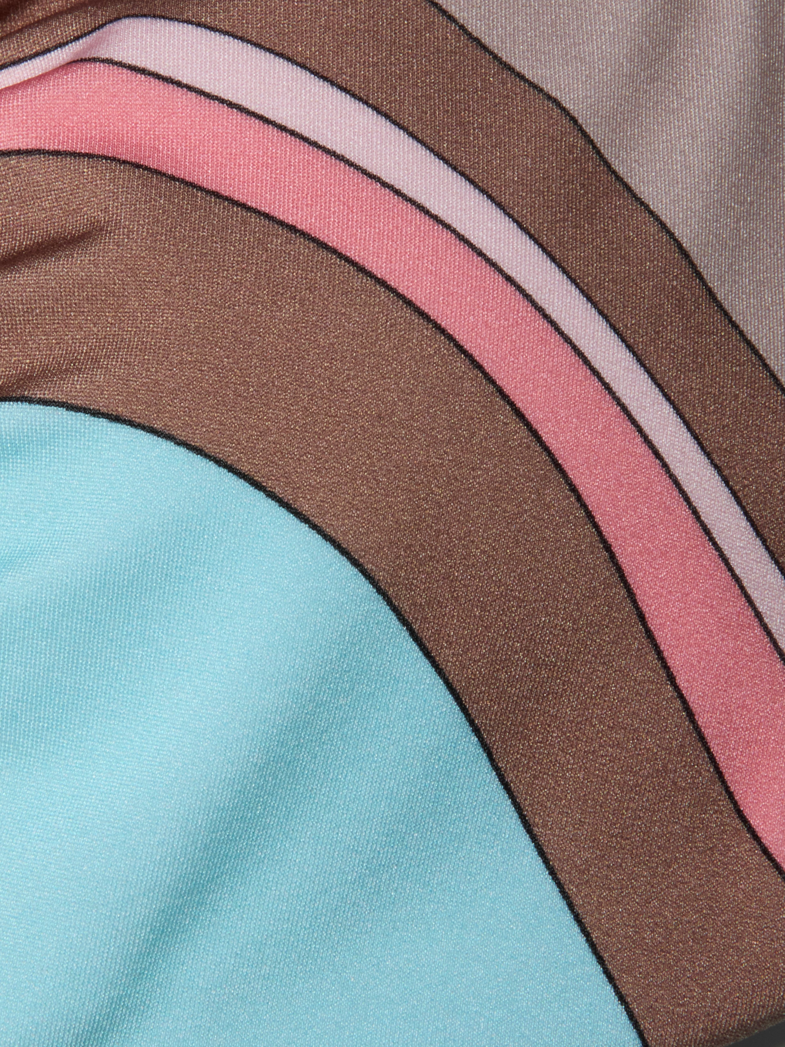 Gros plan sur le tissu du haut de bikini Annabelle, qui présente des rayures incurvées de couleur marron, rose et violet clair, ainsi quune large zone bleu clair. Le motif abstrait en forme de tourbillon et la légère brillance donnent à ce haut de bikini un aspect moderne et élégant.