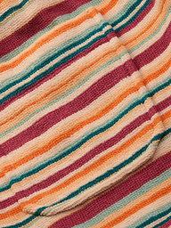 Close-up of the Amiya Cover-Up Short, showcasing its textured fabric with horizontal stripes in shades of orange, pink, cream, and teal. The soft, subtly ribbed material evokes the comfort of cozy terrycloth—perfect for poolside lounging.
