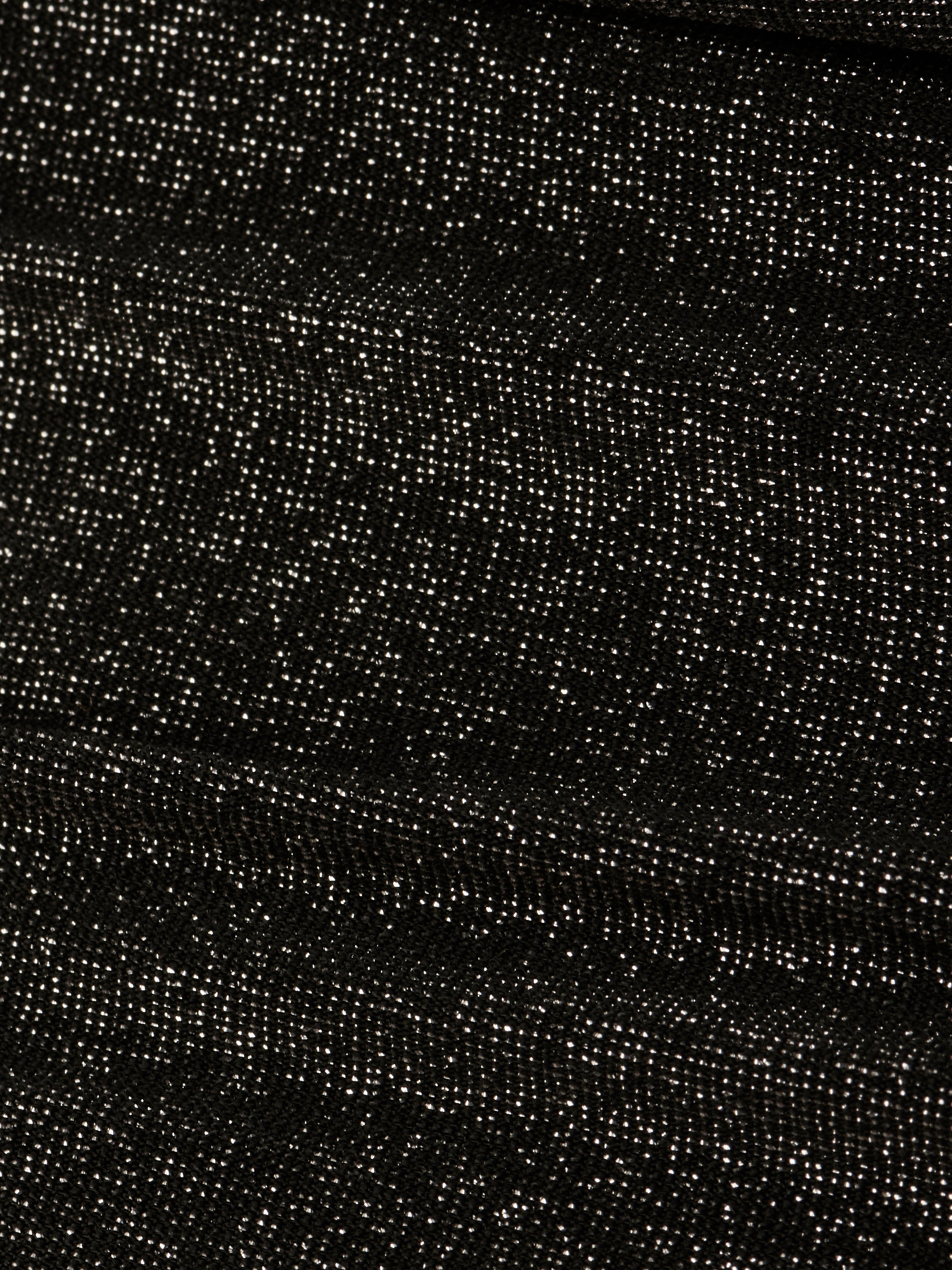 Close-up of the Nicole Bikini Bottom’s textured metallic black fabric, featuring small white specks evenly distributed across the surface for a starry, glittery effect.