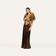 A woman stands in a long, brown sequined gown exuding plush glamour, her shoulders elegantly draped in the Hazel Faux Fur Stole—a statement accessory—set against a plain white background.