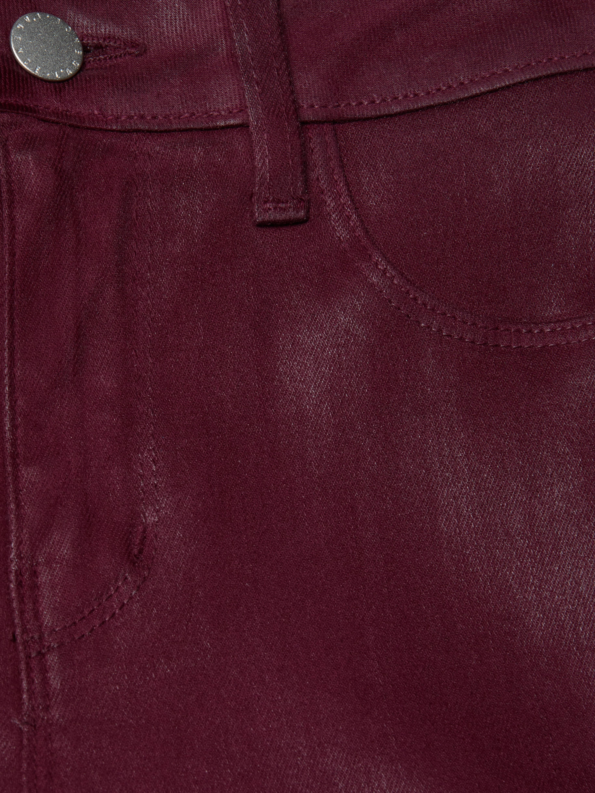 Close-up of the Selma Coated Bootcut Jean in maroon shows a pocket, belt loop, and metallic button. The coated denim’s texture and stitching details are highlighted in this high-rise baby bootcut style.