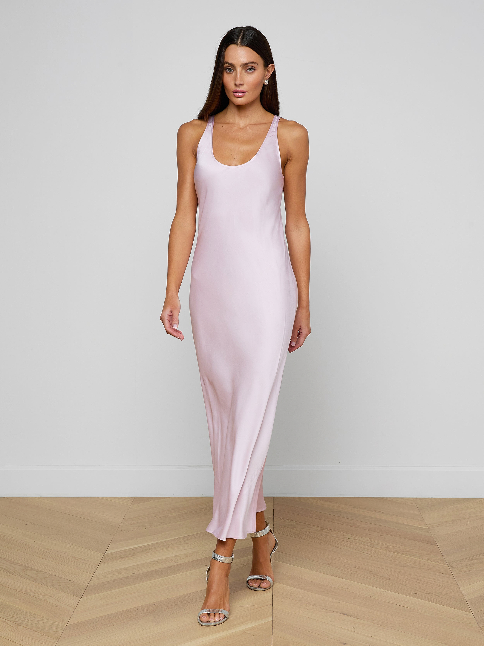 A woman wearing the Akiya Satin Maxi Dress in pastel lilac and strappy heels walks confidently against a plain white background.