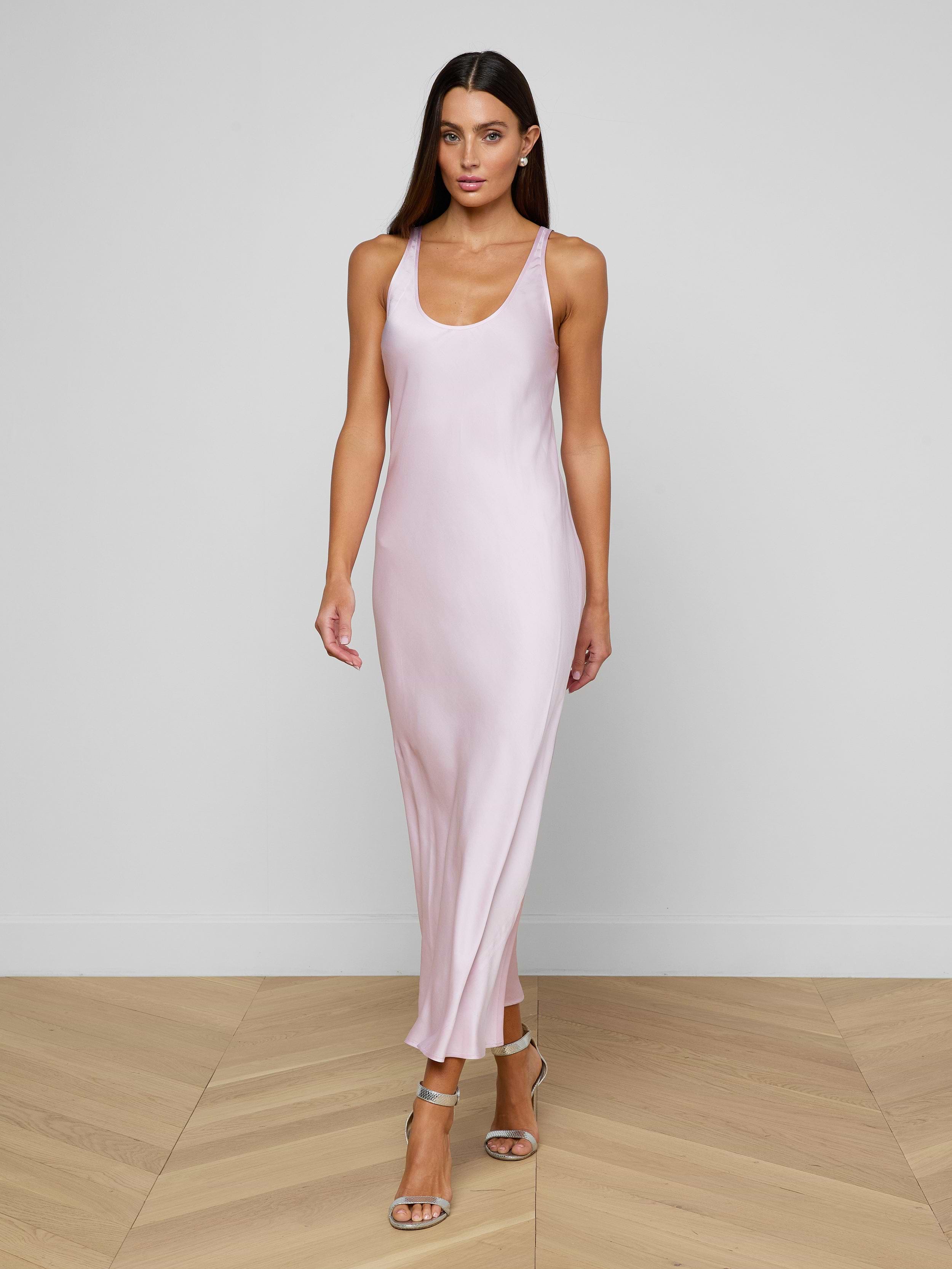 A woman wearing the Akiya Satin Maxi Dress in pastel lilac and strappy heels walks confidently against a plain white background.