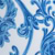 Blue and white decorative floral pattern with swirls and leaf shapes, resembling ornate ceramic or wallpaper design.