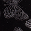 Close-up of a black fabric with an embroidered butterfly design in shiny, dark thread.