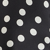 Close-up of a black fabric with a white polka dot pattern.