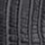 Close-up of a textured dark surface with vertical and slightly curved ridges and grooves, resembling reptile or crocodile skin.